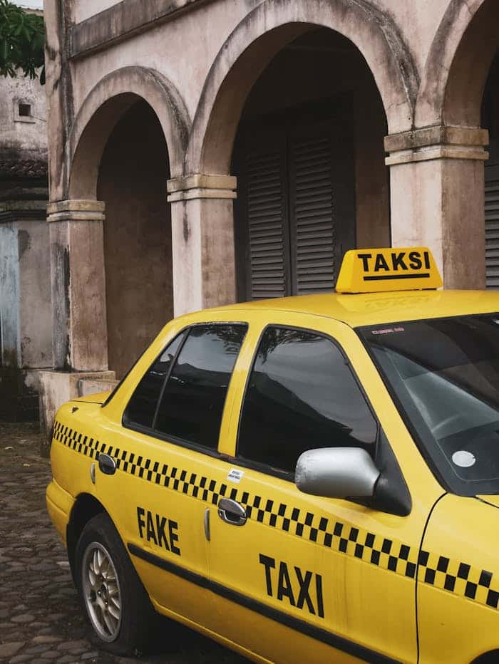 Crafting Captivating Headlines: Your awesome post title goes here A yellow taxi with "FAKE TAKSI" sign parked in front of an old architectural building.
