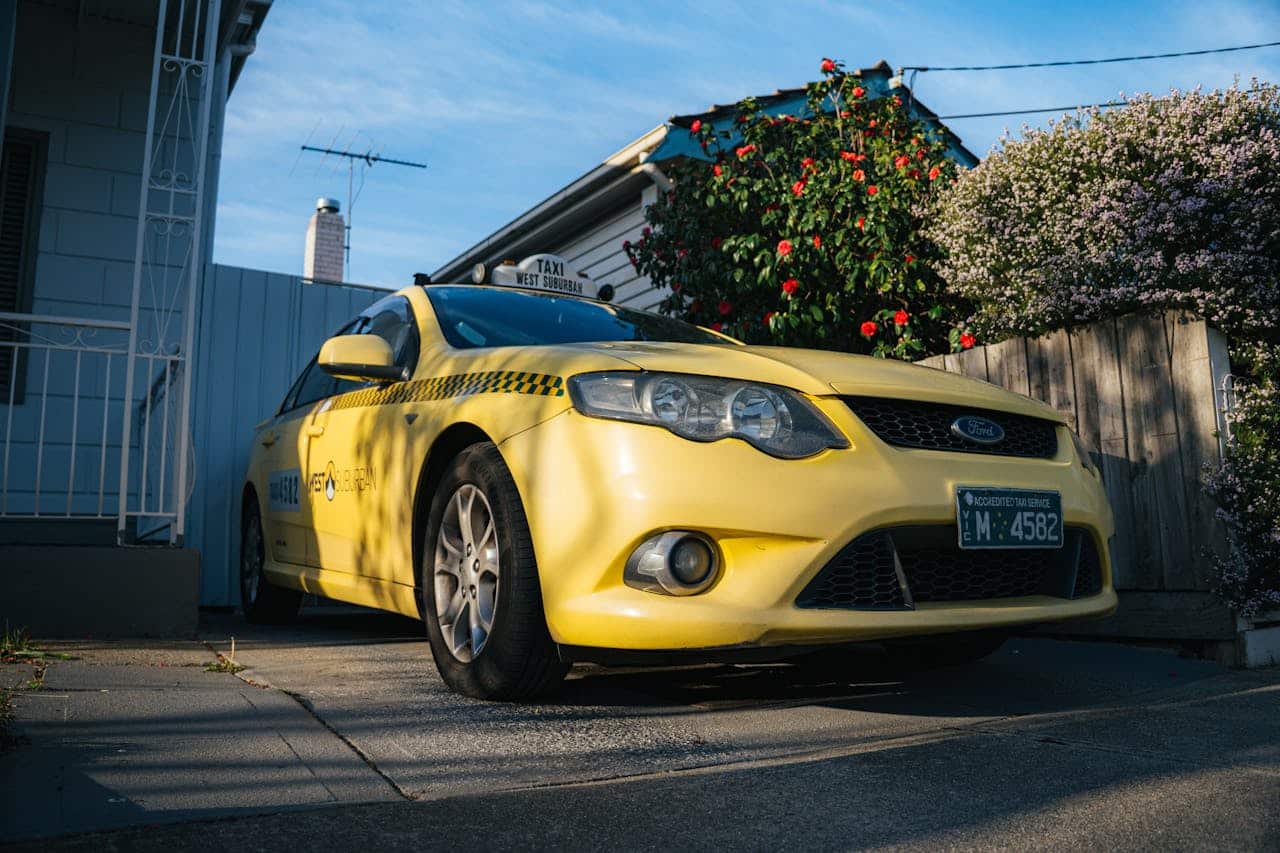 The Art of Drawing Readers In: Your attractive post title goes here A bright yellow taxi parked in a suburban driveway in Yarraville, showcasing urban lifestyle.